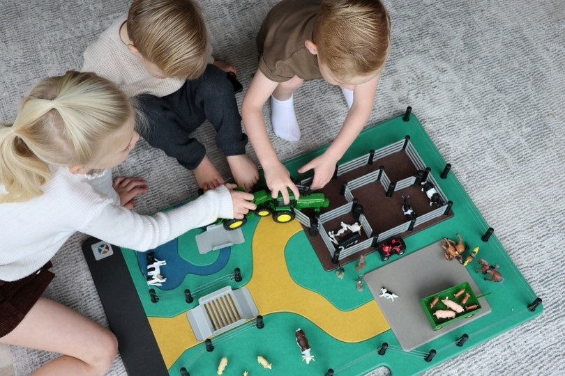 children playing with farm board